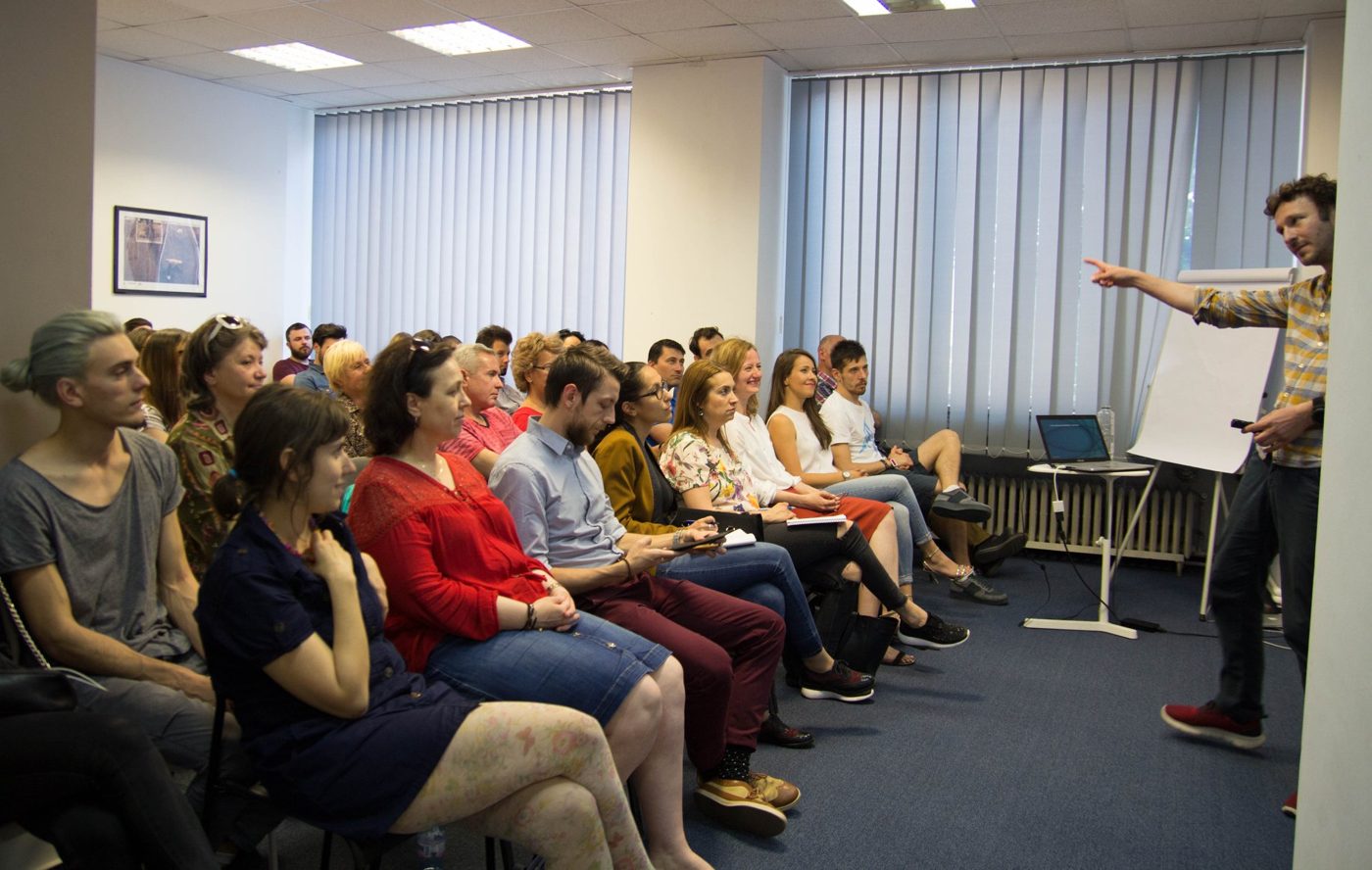 Edgar Nistor la flipchart în fața unei săli pline, seminar Tehnica de casting